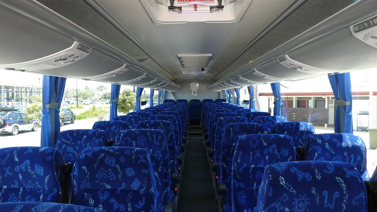 Interior executivo de ônibus de turismo com poltronas reclináveis e cortinas