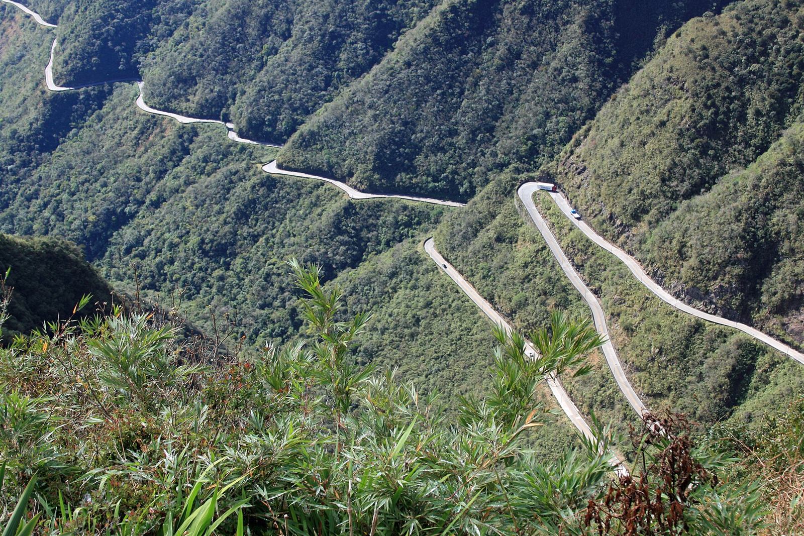 Sequência de curvas fechadas da Serra do Rio do Rastro (SC) em dia claro, encostas cobertas de mata verde